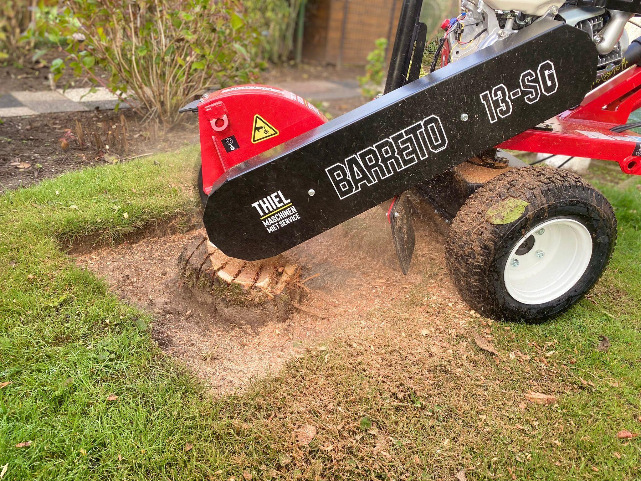 Barreto 13-SG Stubbenfräse beim Entfernen eines Baumstumpfes im Rasen, mit Holzspänen und Erde am Arbeitsbereich.